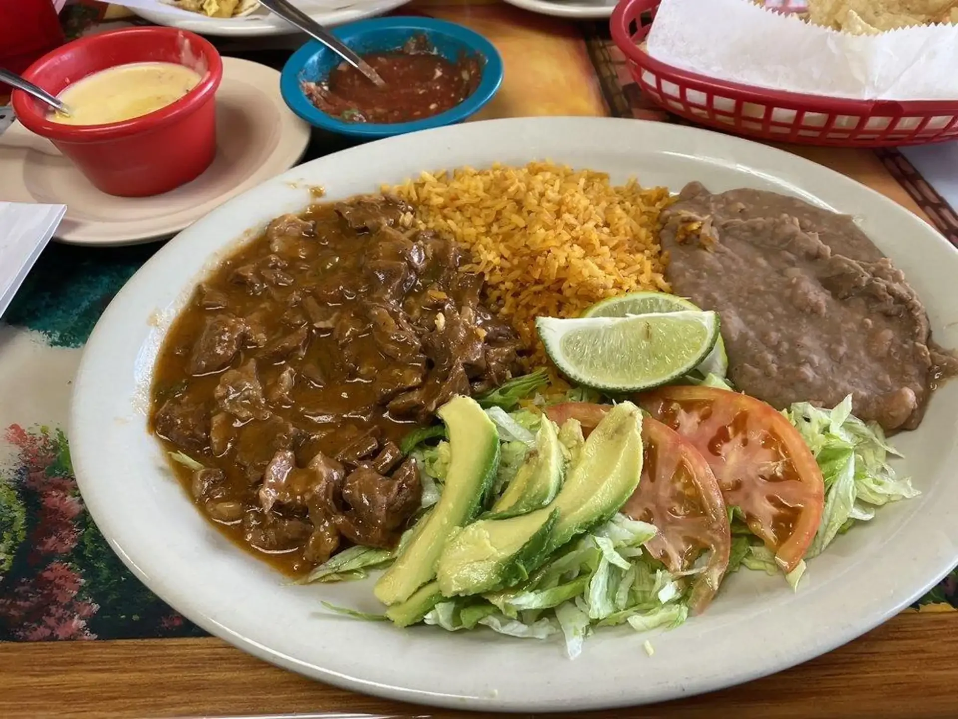 Carne Guisada - Slow-braised beef in a rich, savory gravy — a Tex-Mex comfort food staple. Served with rice, beans, and warm flour tortillas.